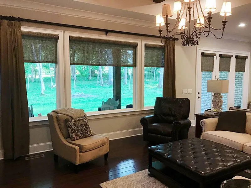 Layered drapery and woven shades in a living room