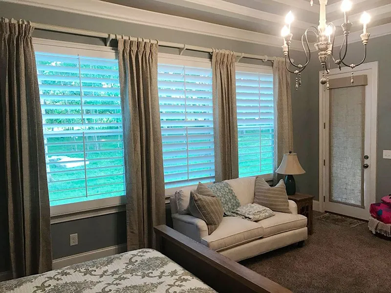 Layered drapery and shutters in a living room
